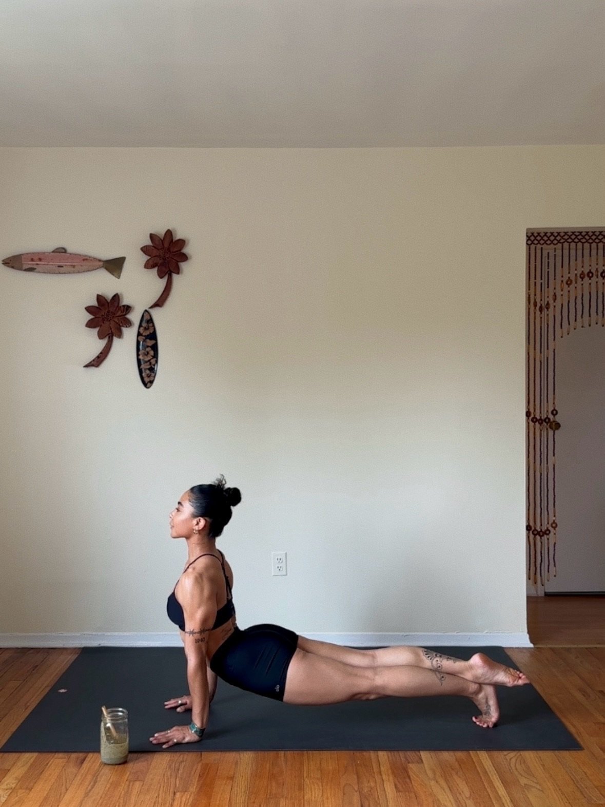 Yoga creator in upward facing dog pose with Just Protein green smoothie on mat - lifestyle creator content for Just Protein product launch