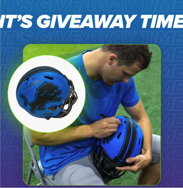 Detroit Lions tight end Sam LaPorta signing a helmet for a Genisys Credit Union giveaway